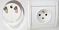 Stecker Typ E CEE 7/5 mit Erdungsstift in der franz&ouml;sischen Steckdose